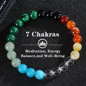 Macro view of 8mm 7 chakra natural stone energy beads bracelet on black leather background