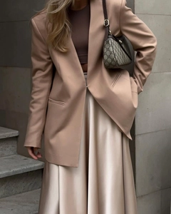 Close-up of elegant champagne satin maxi skirt with smooth texture and high-waist fit