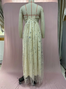 Detail of cream yellow mesh dress showing silver star sequins and open back design