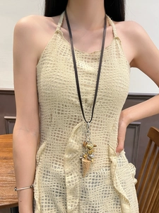 Bohemian ivory necklace featuring gold heart and silver bear pendants on a dark cord