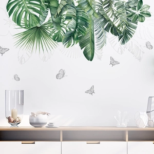 Detailed wall sticker showing tropical monstera leaves and line art butterfly on white wall