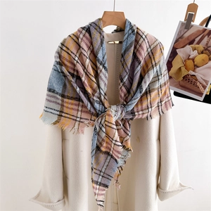 Detail of pink, blue and yellow plaid scarf with fringe on a white wool coat