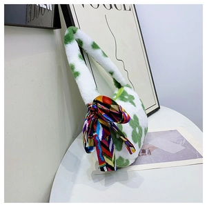 Close-up of soft plush green floral handbag with elegant patterned silk scarf accessory