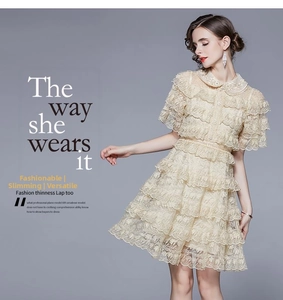 Detail of tiered ruffles and intricate lace patchwork on a beige A-line cake dress