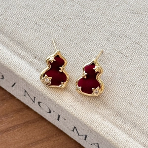 Boucles d'oreilles gourde dorées avec velours rouge et étoiles en zircon sur livre
