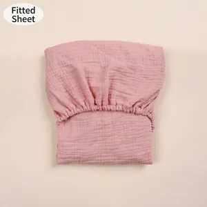 Detailed view of pink cotton gauze fitted sheet with elasticated edges for baby cradles