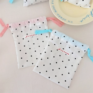 Macro detail of blue and pink polka dot drawstring storage bags with cotton texture