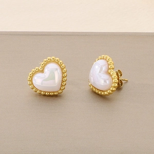 Macro detail of golden heart studs with white shell inlay and beaded edges for women