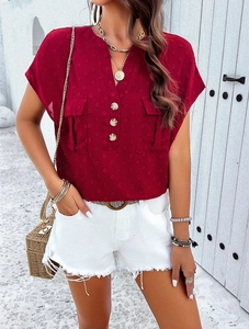 Detail of red V-neck blouse featuring textured Swiss dots and decorative front buttons