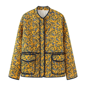 Detailed view of yellow floral quilted jacket with blue flower pattern and large pockets