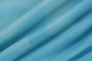 Gros plan sur un tissu en maille bleu clair avec texture fine et drapé élégant