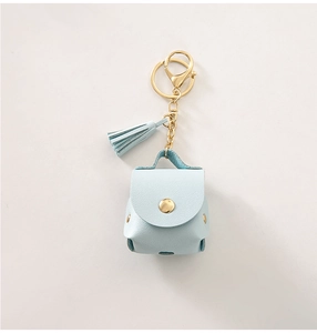 Macro shot of light blue PU leather mini coin pouch with gold keychain and tassel detail