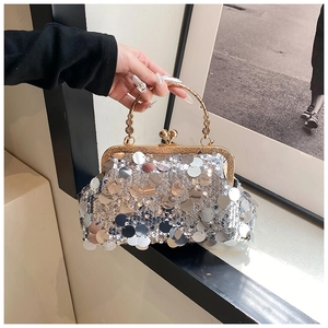 Detail of silver sequin handbag featuring gold floral metal handle and clasp closure