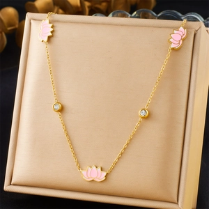 Detail of gold chain necklace with pink lotus charms and sparkling inlaid diamonds