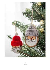 Nahaufnahme von Holz-Weihnachtsmann-Anhängern mit Strickmützen an einem Weihnachtsbaum