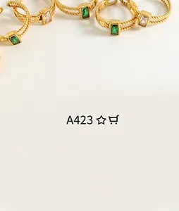 Close-up of twisted rope-style gold ring featuring rectangle emerald and zircon stones