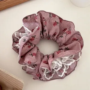 Chouchou élégant rose poudré avec motif floral et bordure en dentelle blanche