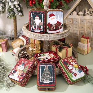 Detailed view of Christmas tin boxes with festive Santa and snowman patterns on a tray