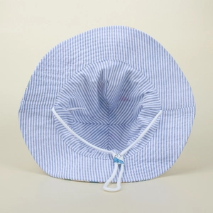 Detail of blue striped baby sun hat featuring the adjustable white chin strap buckle