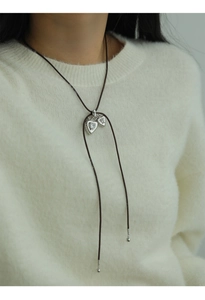 Detail of silver double heart pendant with textured finish on a dark adjustable cord