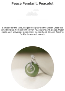 Detailed close-up of dark green jade pendant with silver wire-wrapped finish on a fine chain