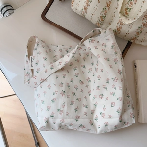 Close-up of floral cotton shoulder bag with simple wish label and soft fabric texture