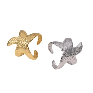 Starfish open rings in gold and silver finish with textured surface on white background
