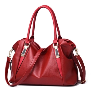 Close-up of red leather tote bag showing high-quality texture and golden hardware details