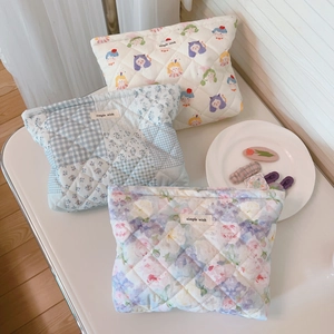 Detailed view of quilted cotton cosmetic bags in floral, cartoon, and flower patterns