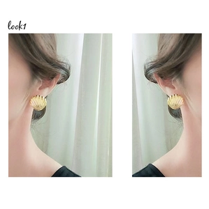 Macro detail of golden scallop shell earrings with textured radial relief patterns