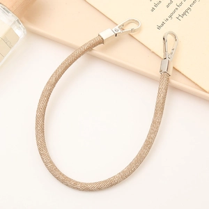Detail of light brown woven PU leather strap with silver metal spring clasps for accessories