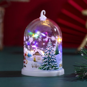 Close-up of a festive Christmas night light featuring a snow scene and glowing LED dome