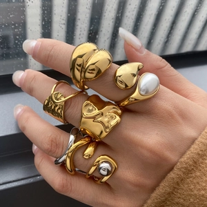 Irregular gold and silver stainless steel rings set with pearl detail on female hand