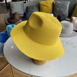 Detailed close-up of spiral woven yellow straw fedora hat with a classic jazz brim