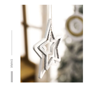 Detail of wooden star Christmas ornament with silver glitter finish and XMAS lettering
