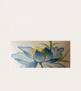 Macro detail of hand-painted lotus pattern on a blue ceramic airtight tea canister