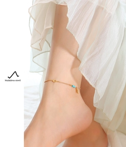 Detailed shot of a gold-plated stainless steel anklet with turquoise beads and leaf charms