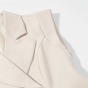 Close-up of beige sleeveless blazer vest lapel and premium shoulder tailoring details