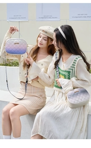Detail of gradient quilted shoulder bags in purple and grey with wide patterned straps