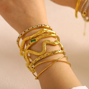 Adjustable gold layered bracelet set featuring a snake design with green stones and zircons