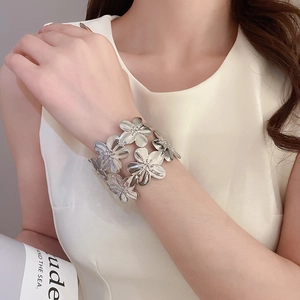 Macro view of silver floral cuff bracelet with intricate metallic petal layers and shine