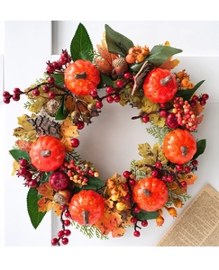 Detail of autumn wreath with orange pumpkins, red berries, and colorful maple leaves