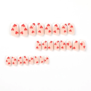 Matte press-on nails with white French tips and red hearts on a soft pink base