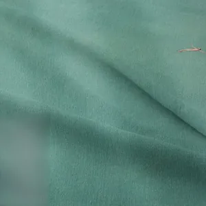 Macro detail of teal bohemian wall tapestry fabric showing high-quality woven texture