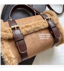 Detail of brown faux suede crossbody bag featuring plush trim and gold metal buckles