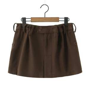 Gros plan sur la mini-jupe marron en laine mélangée avec boutons décoratifs et texture du tissu