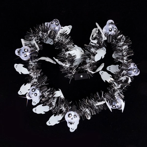 Detail of a heart-shaped Halloween wreath with ghost cutouts and LED skull lights