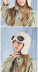 Detail of cream white kids aviator knit hat with goggles and warm fleece lining