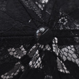 Close-up of black lace fabric and button detail on top of a butterfly baseball cap