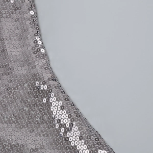 Détail de paillettes argentées scintillantes sur une robe de soirée, texture métallique